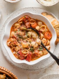 Bowl full of easy minestrone soup with chicken topped with Parmesan and fresh parsley.