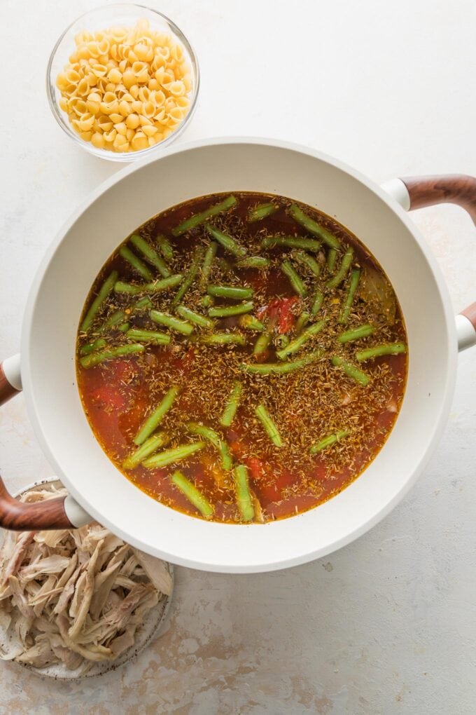 Broth and green beans added to the base of a minestrone soup.