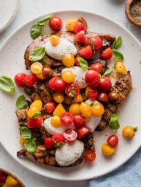 Platter filled with grilled balsamic chicken topped with mozzarella medallions, quick-marinated tomatoes, and fresh basil leaves.