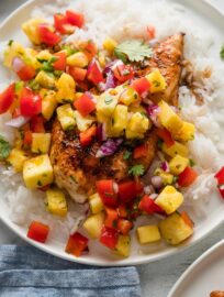 Close up of brown sugar chicken cutlets with fresh pineapple salsa served over rice.