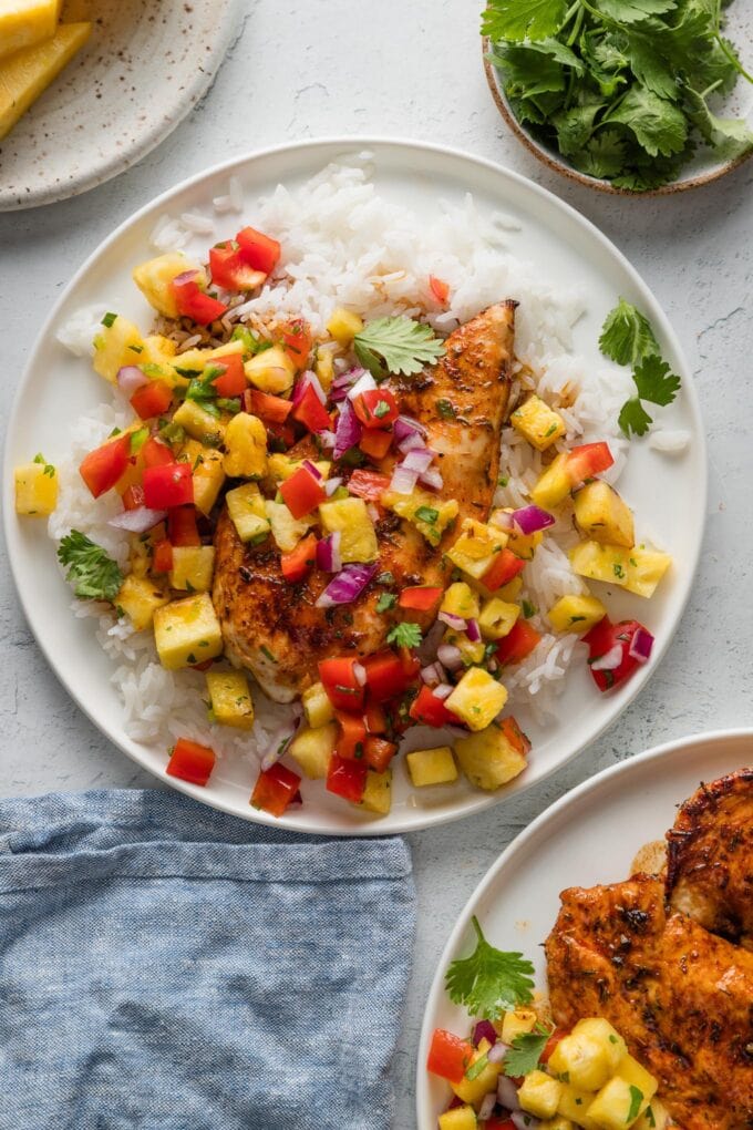 Countertop set with plates of brown sugar chicken with pineapple salsa and rice.