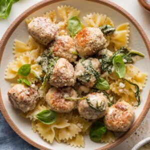 Bowl full of pasta with chicken Florentine meatballs.