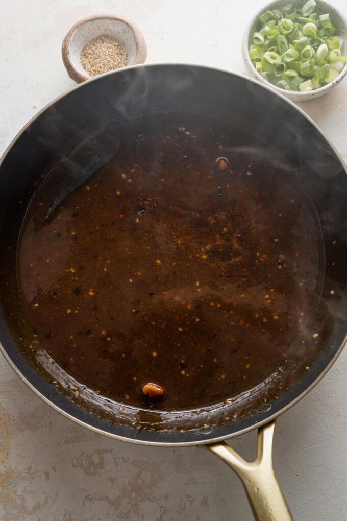 Homemade soy-orange sauce simmering in a large saucepan.