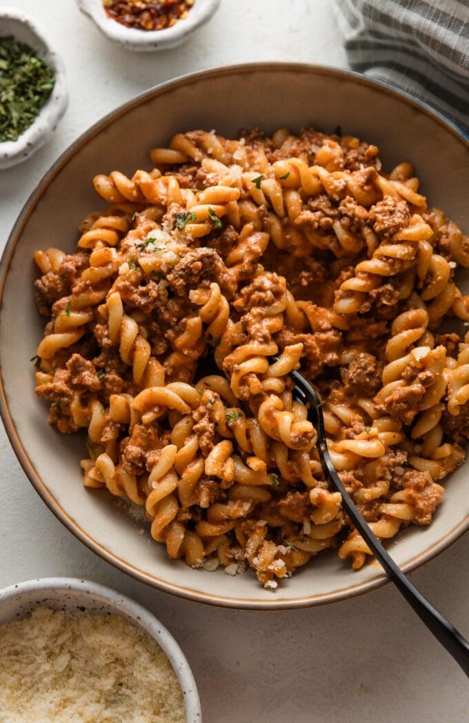 Rotini pasta dish with meat sauce in a small pasta bowl.