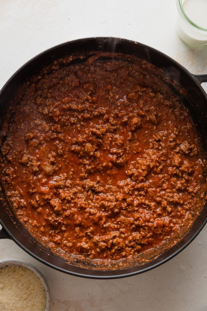 Quick homemade tomato meat sauce simmering in a deep cast iron skillet.