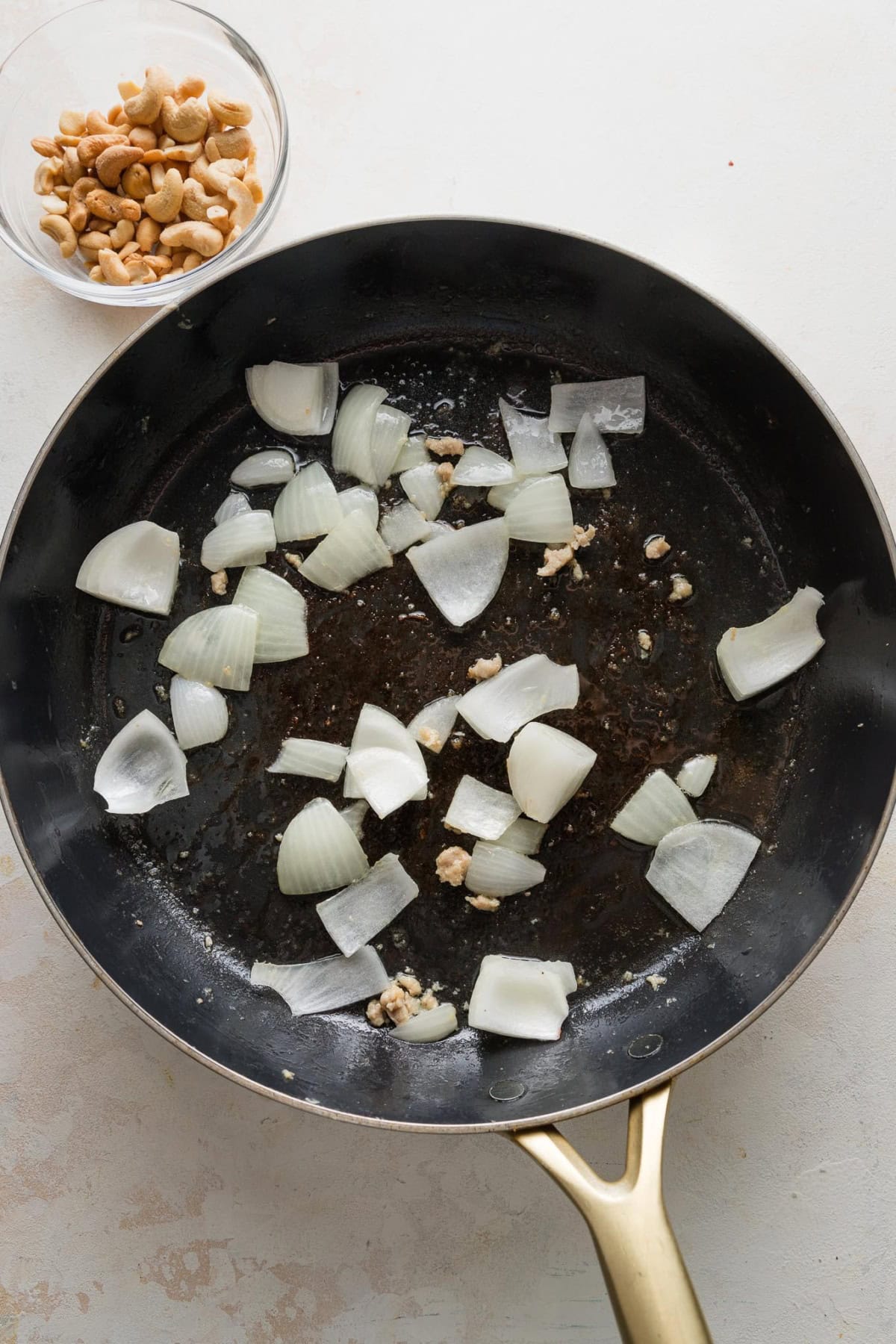 Onions cut into bite-sized pieces and cooked briefly in a large pan.
