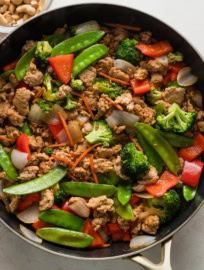 Large skillet full of a kid-friendly, mild ground chicken stir fry, with a sauce of soy sauce and honey plus a rainbow of veggies to choose from.