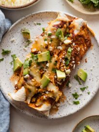 Small dinner plate full of two enchiladas made with shredded rotisserie chicken.