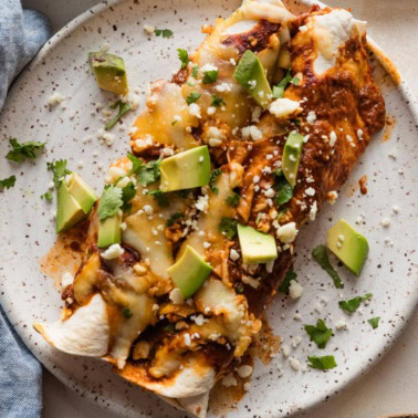 Small dinner plate full of two enchiladas made with shredded rotisserie chicken.