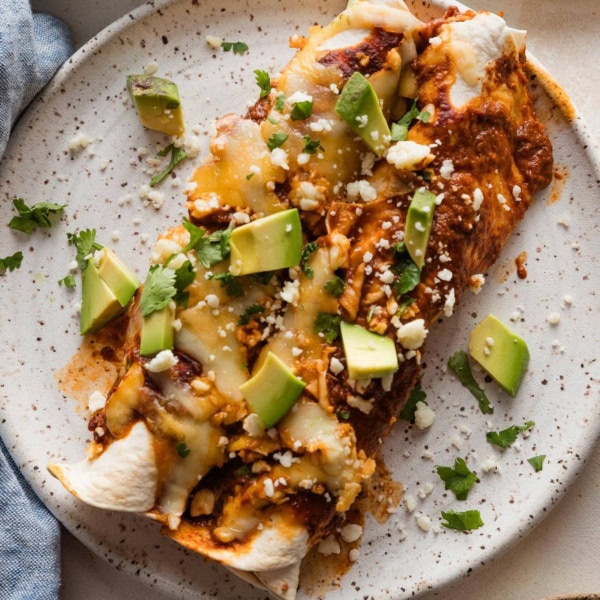 Small dinner plate full of two enchiladas made with shredded rotisserie chicken.
