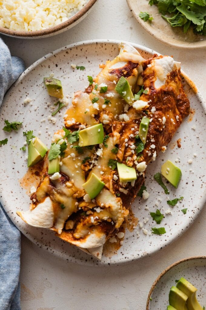 Small dinner plate full of two enchiladas made with shredded rotisserie chicken.