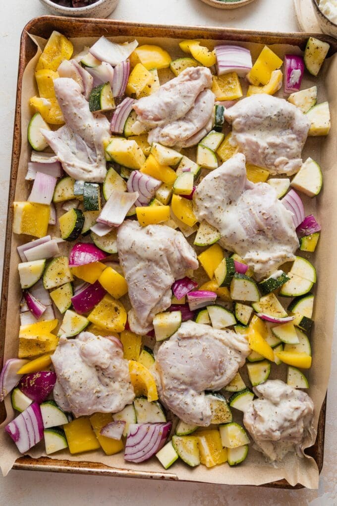 Yogurt-marinated chicken thighs nestled in among veggies.