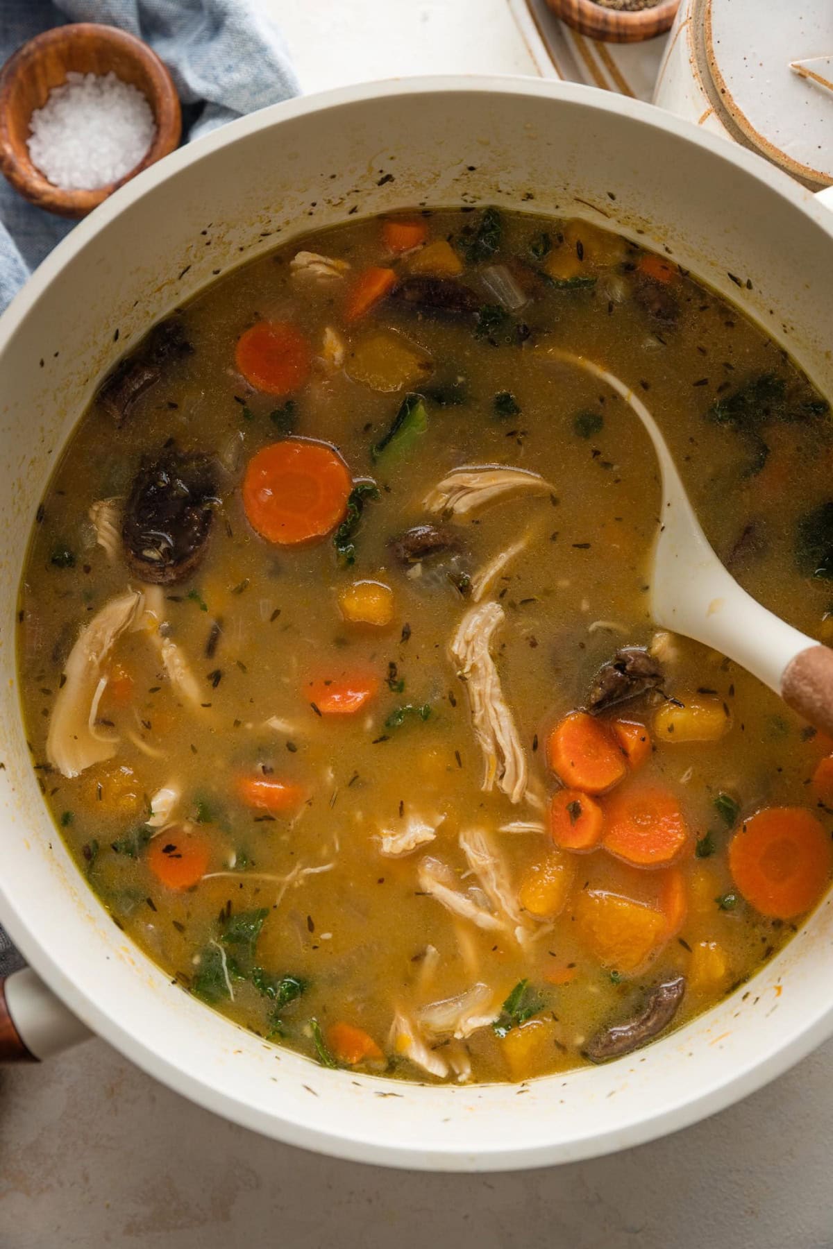 White pot filled with a butternut squash wild rice soup.