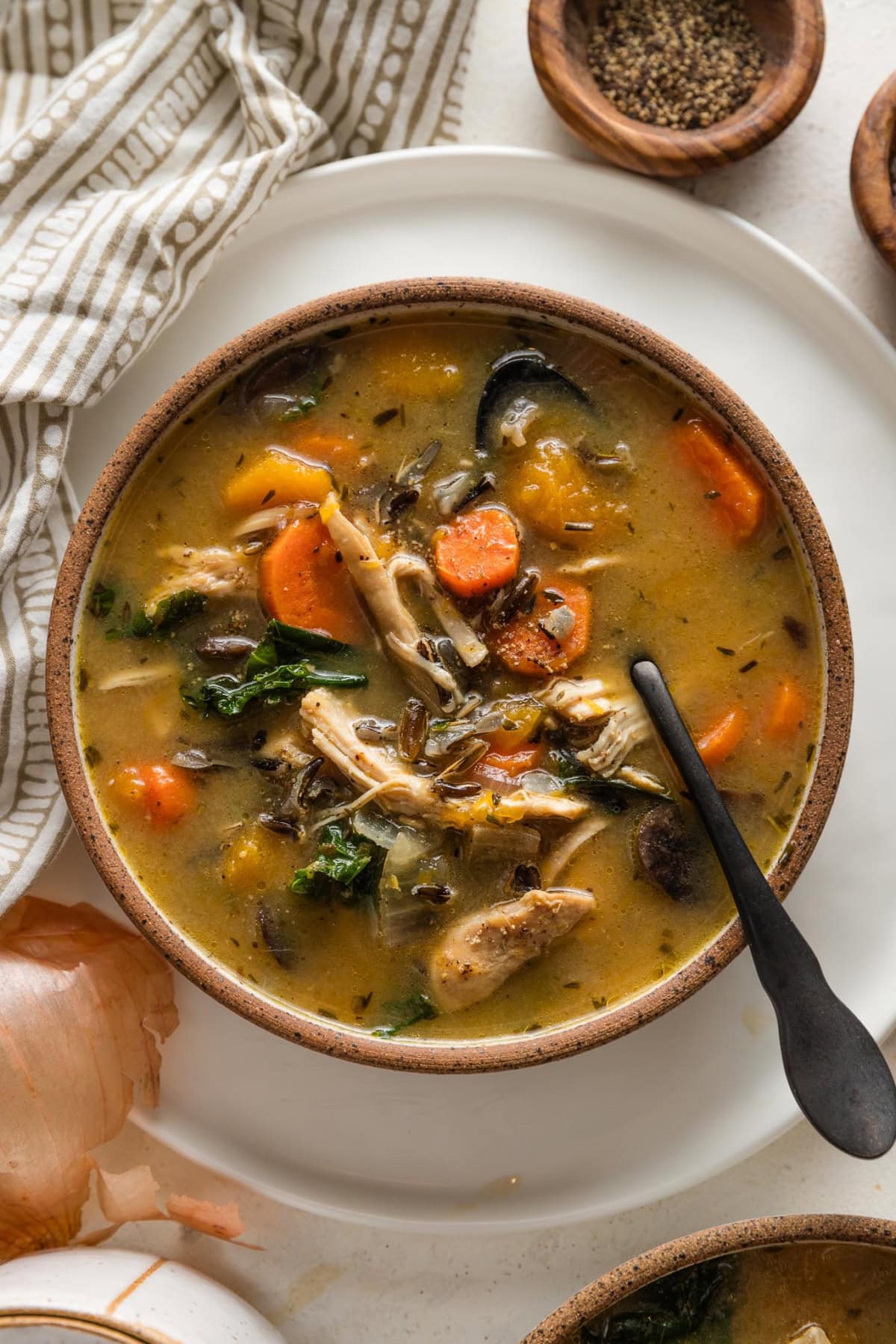 Small ceramic bowl filled with a fall soup of wild rice, chicken, and butternut squash.