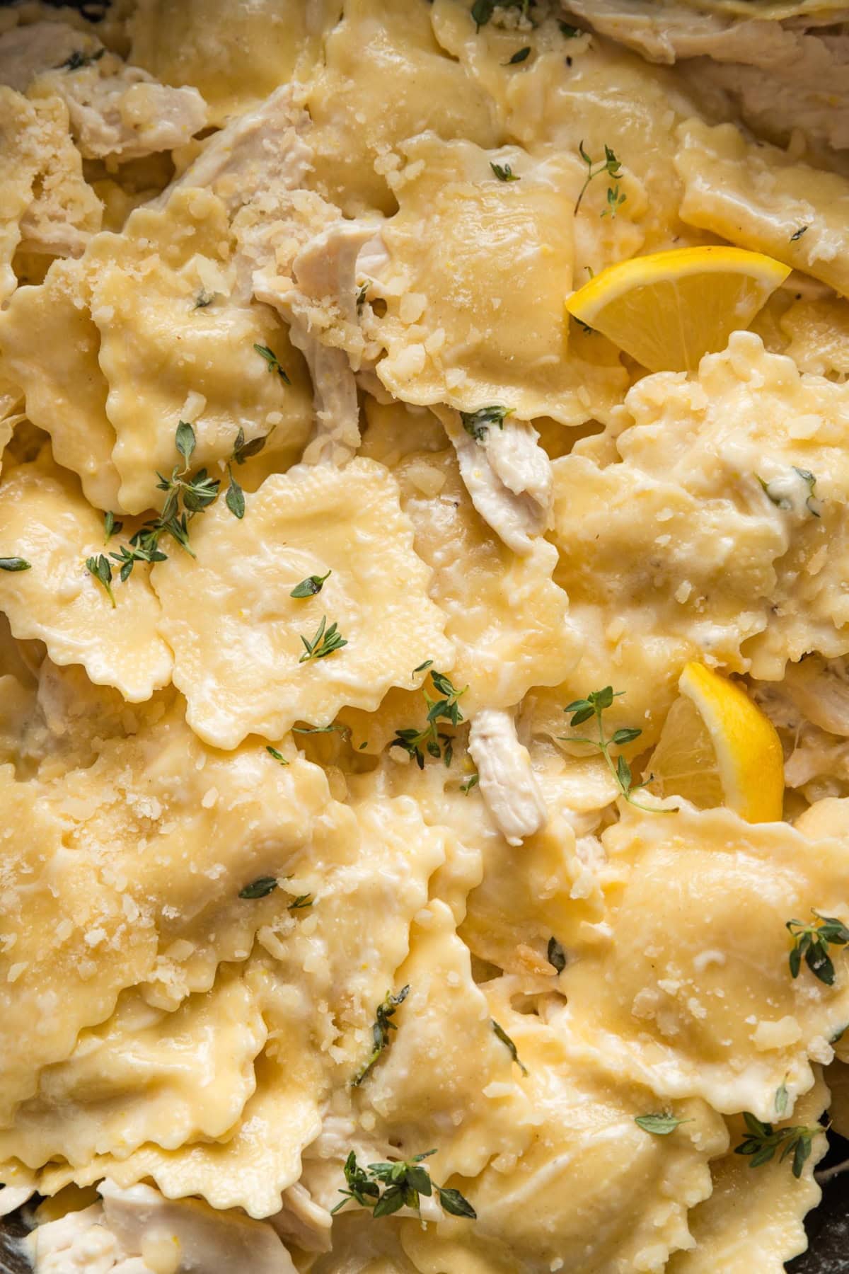 Close up of cheese ravioli in a creamy lemon garlic sauce with Parmesan and fresh thyme.