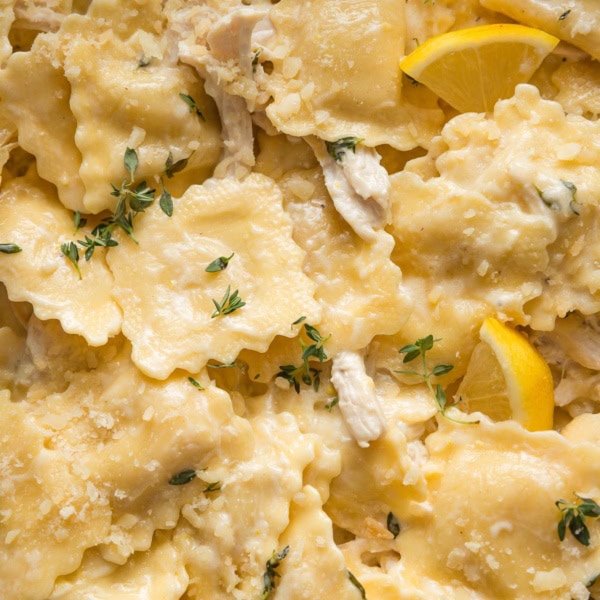 Close up of cheese ravioli in a creamy lemon garlic sauce with Parmesan and fresh thyme.