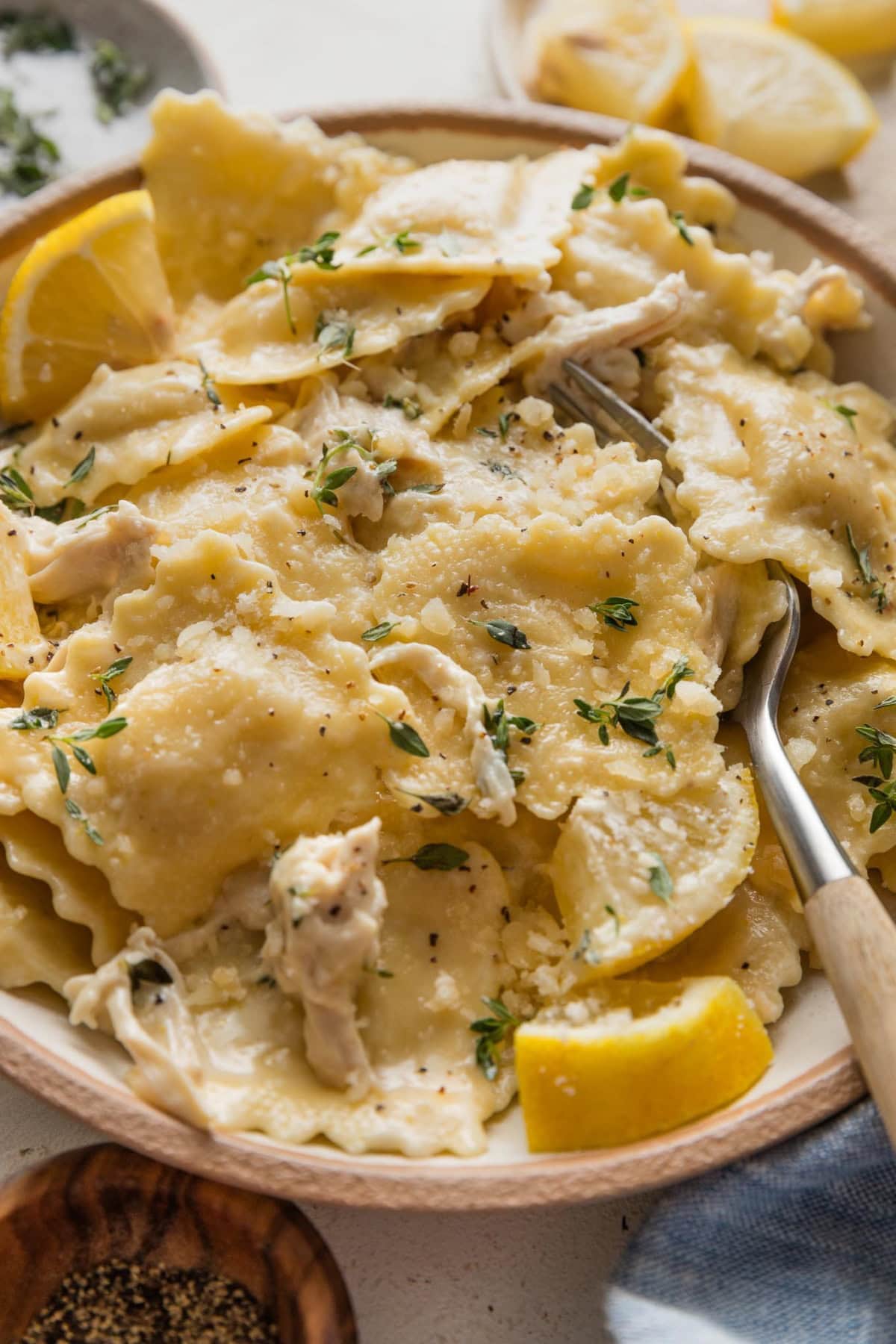Close up of a fork picking up a bite of creamy lemon chicken ravioli.