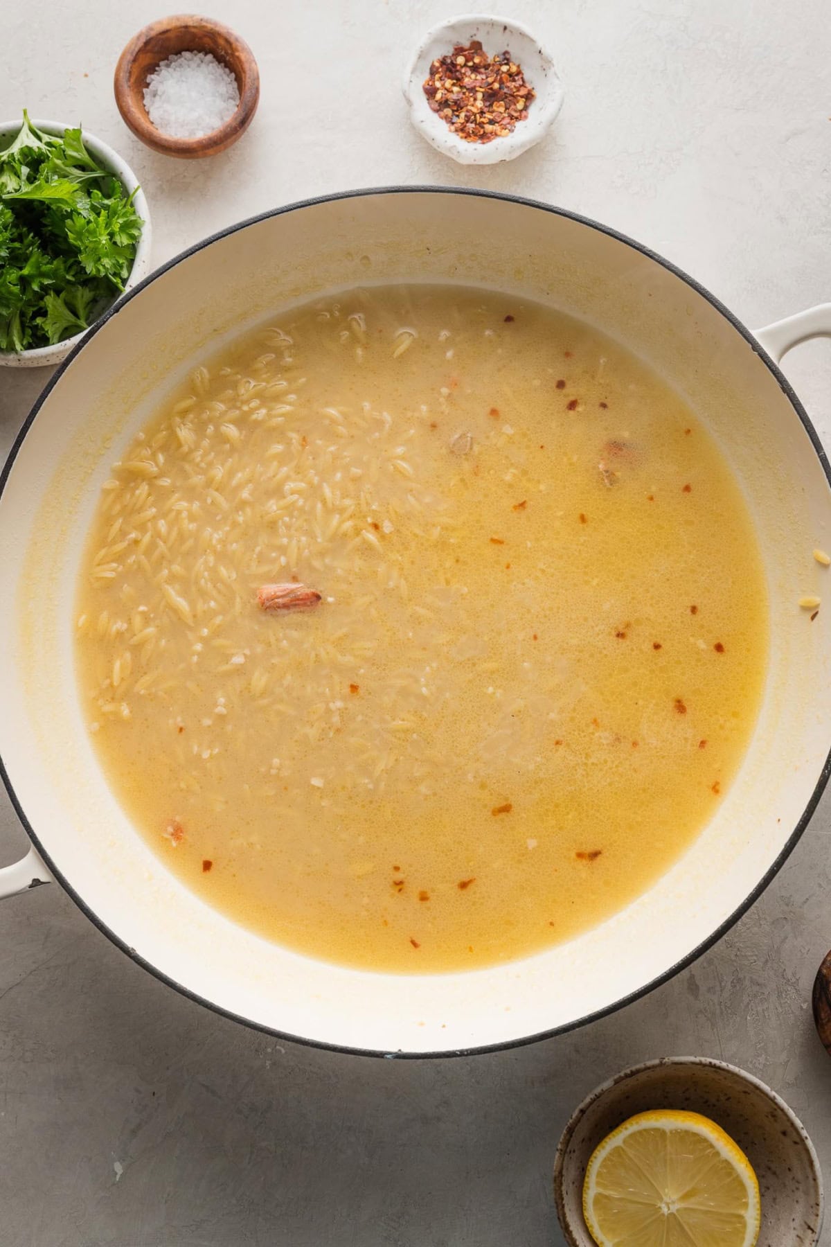 Chicken broth gently simmering with orzo inside.