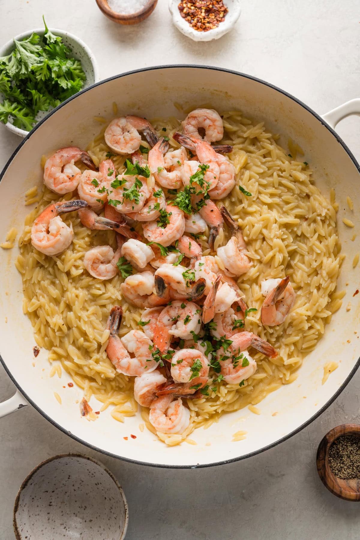 Skillet full of orzo shrimp scampi.