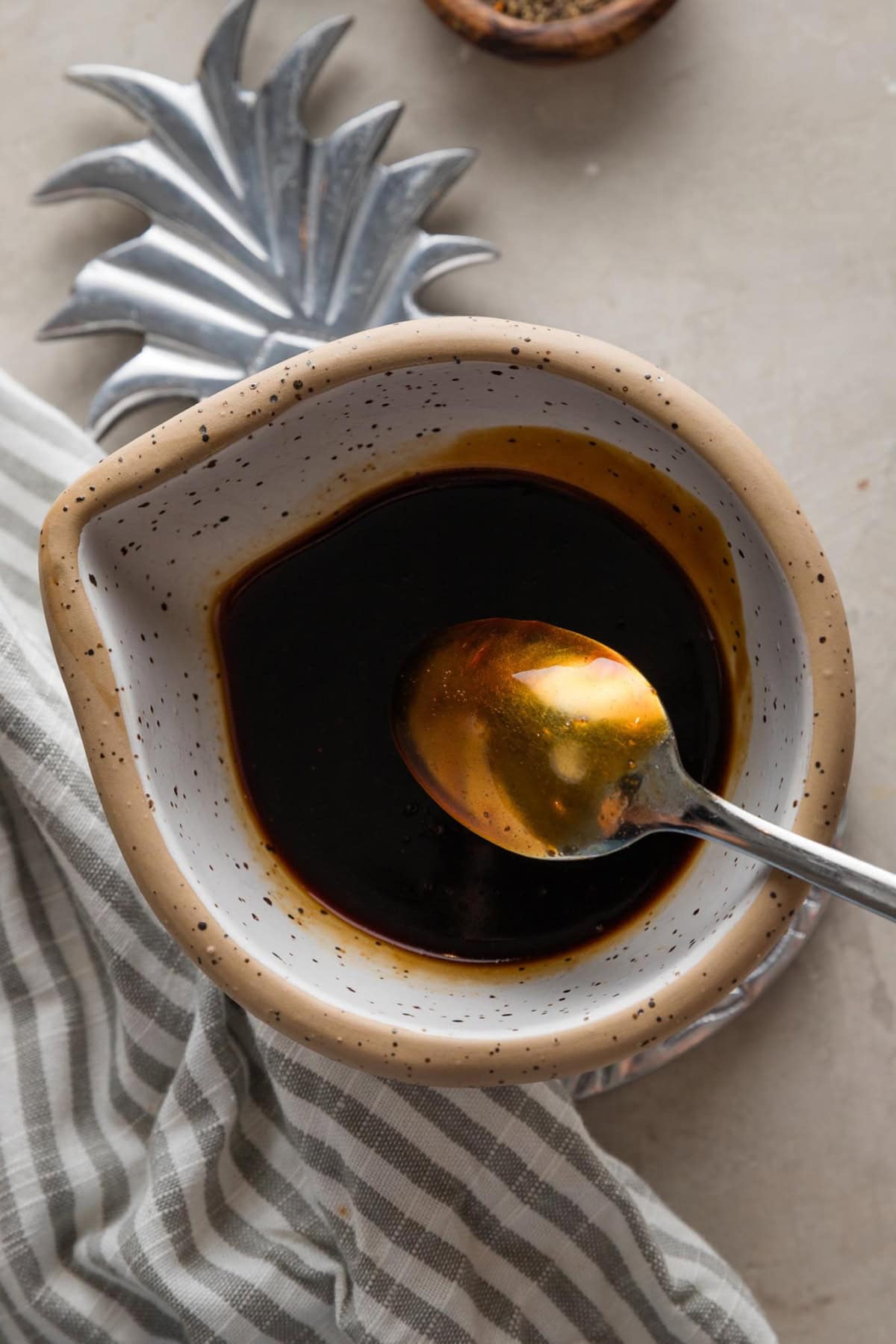 Homemade smooth teriyaki sauce in a ceramic pouring bowl.