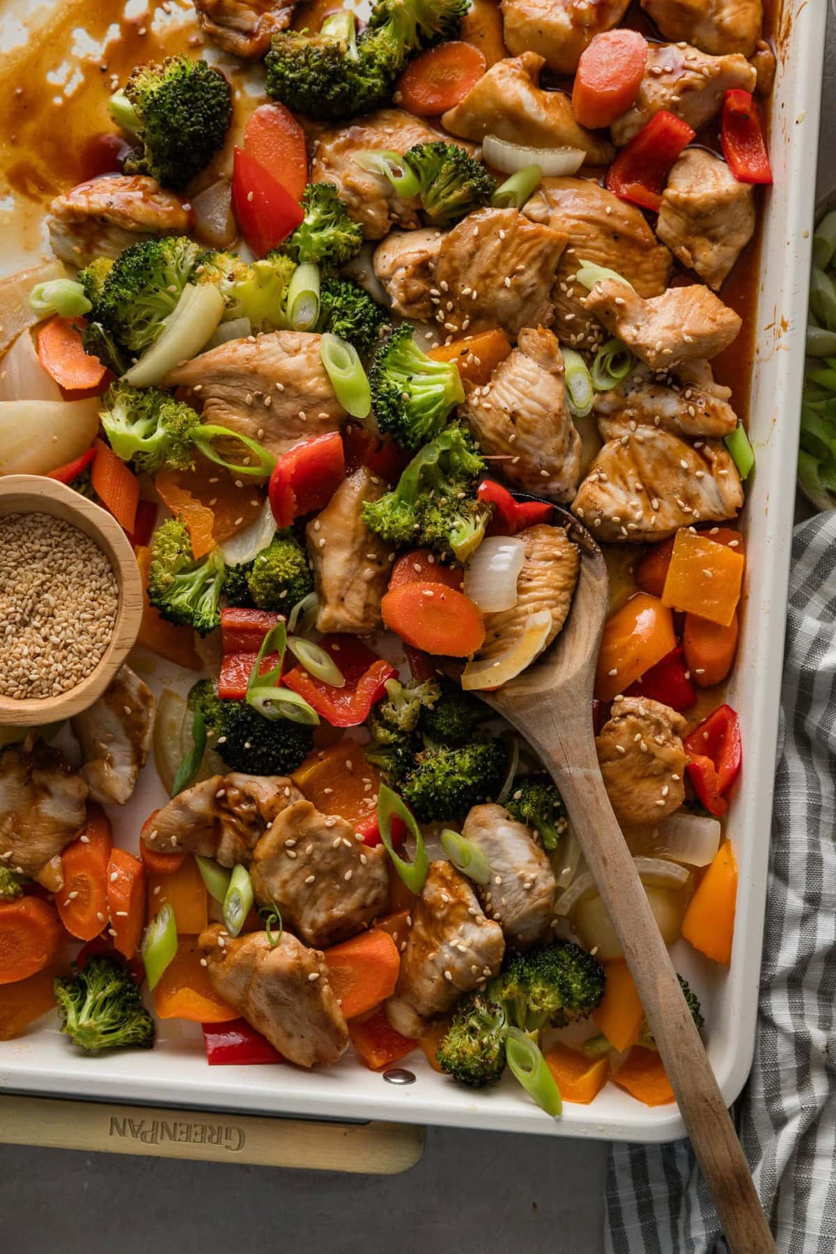 Large enameled sheet pan filled with a one pan baked teriyaki chicken and veggies.
