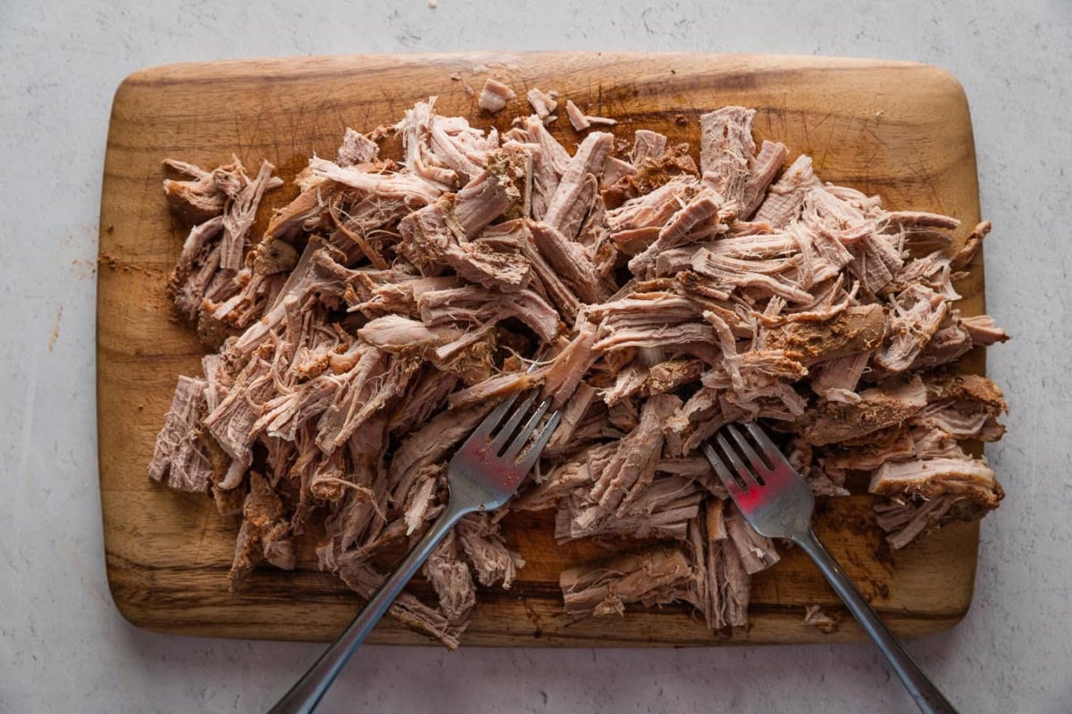 Pulled pork on a cutting board.